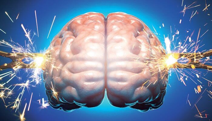 Digital illustration of a human brain glowing with sparks flying from each hemisphere