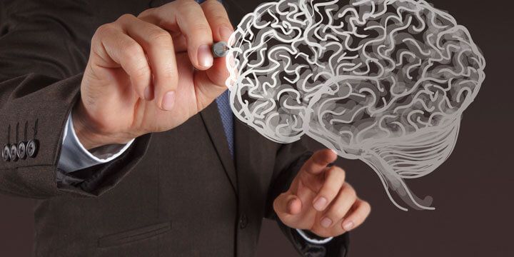 A businessman's hands sketching a glowing illustration of a brain in the air